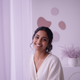 Portrait of a smiling South Asian woman in her late 20s, looking content and trustworthy.